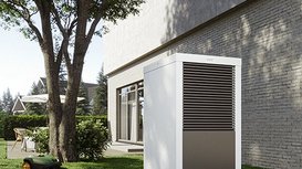 Eine Waermepumpe die im Garten montiert ist